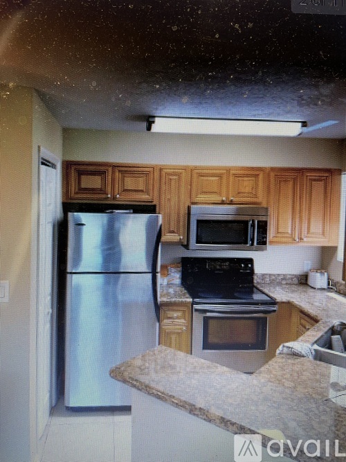 A kitchen with a stainless steel refrigerator, microwave, and oven.