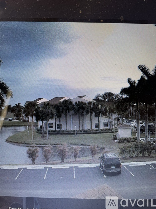 A car is parked in a parking lot in front of a building.