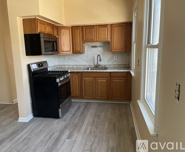 A kitchen with wooden cabinets and a black stove top oven.