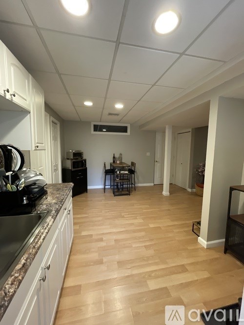 A kitchen with wooden floors and white cabinets.
