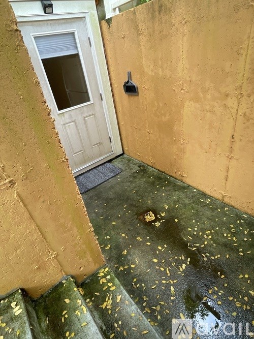 A door with a window is in a room with yellow walls.