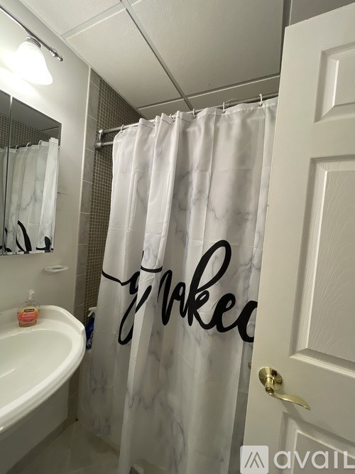 A bathroom with a shower curtain that has the word "wake" written on it.