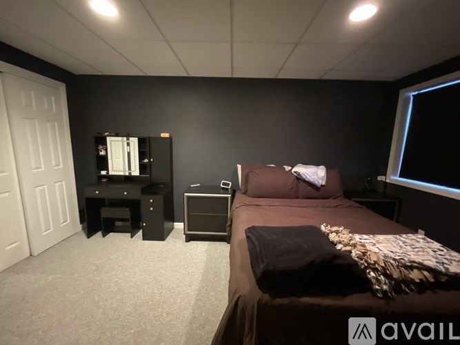A bedroom with a bed, dresser, and mirror.