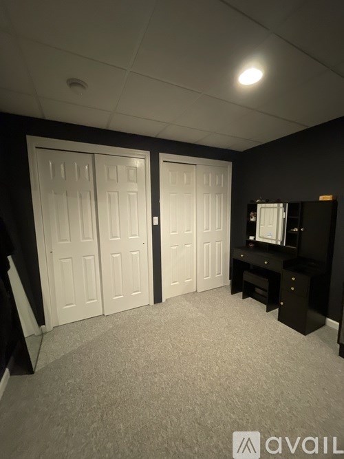 A room with two white doors and a black cabinet.