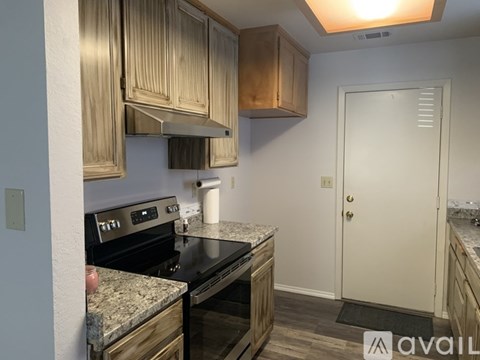 A kitchen with wooden cabinets and a black stove top oven.