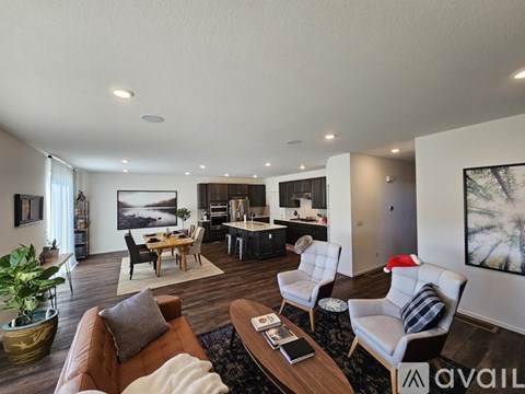 A living room with a brown couch, a coffee table, and a painting on the wall.