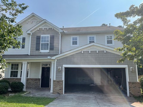 A two-story house with a garage and a driveway.