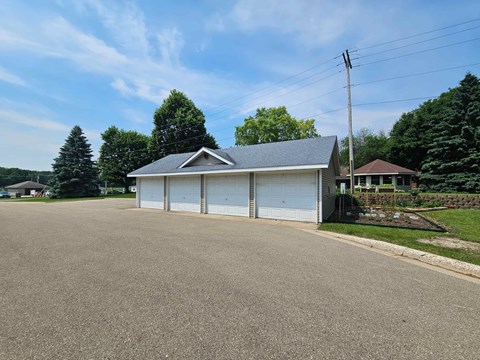 A two-car garage with a white door is situated in a driveway.