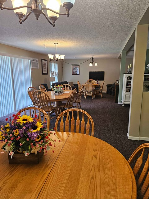 A dining room with a wooden table and chairs.