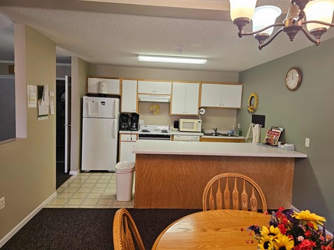 A kitchen with a table and chairs in front of it.