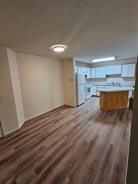 A kitchen with white cabinets and a wooden island.