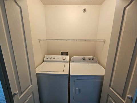 A small laundry room with a washer and dryer.