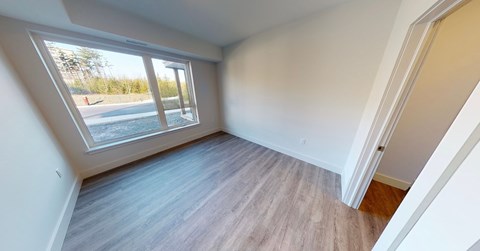 A room with a window overlooking a parking lot.