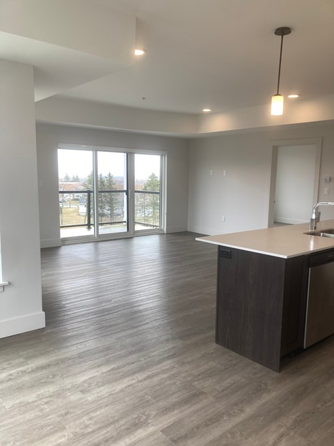 A spacious room with a reception desk and a view of the outdoors through the windows.