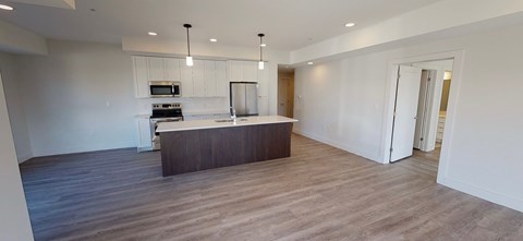 A spacious kitchen with a bar area and a dining table.