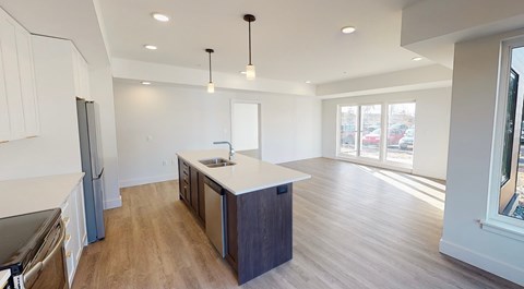 A kitchen with wooden floors and a large island in the middle.