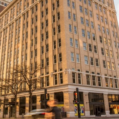 A tall building with many windows is in the foreground.