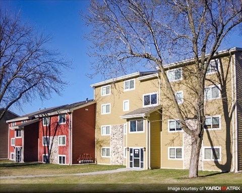 an apartment building with a tree in front of it