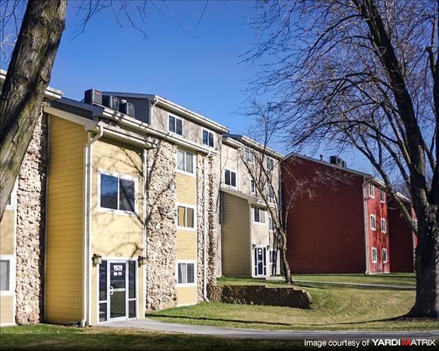 a row of yellow and red apartment buildings with trees
