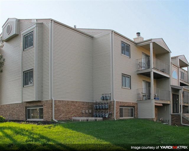 a large apartment building with a yard in front of it