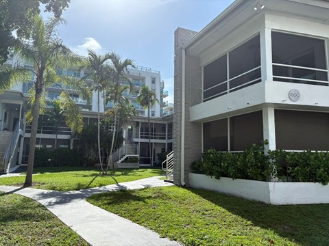 A white building with a balcony and a logo on the wall.