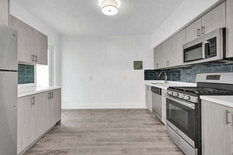 A kitchen with a black stove top oven and white cabinets.