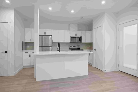A modern kitchen with white cabinets and appliances.
