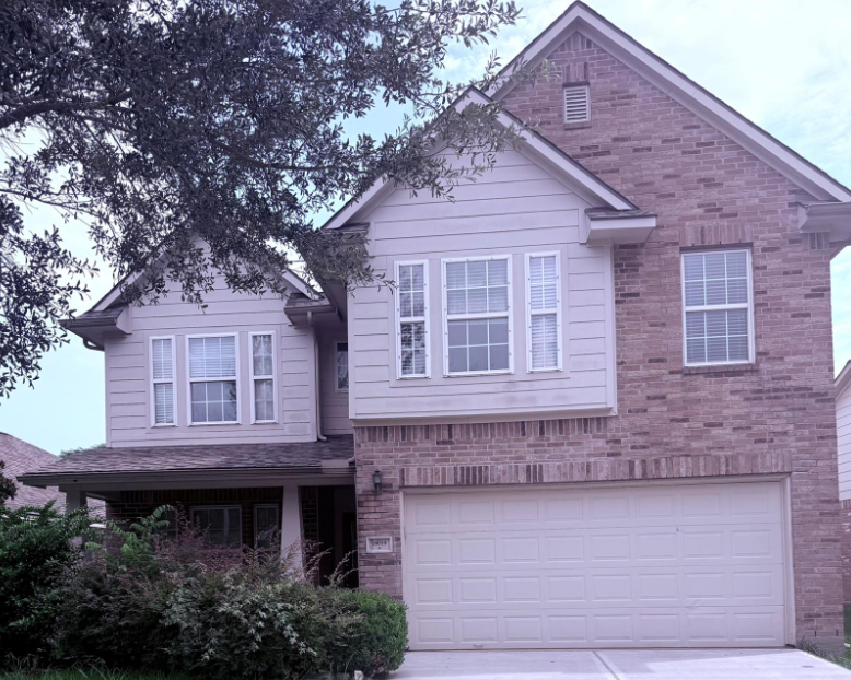 A house with a white garage door and a brick chimney.