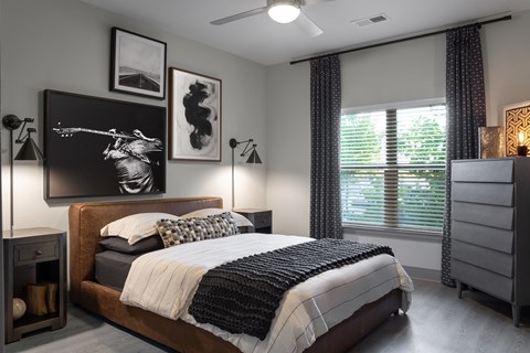 A bedroom with a large bed and a painting on the wall.