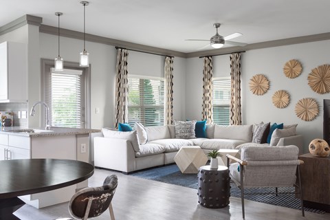 A modern living room with a white couch and a dining table.