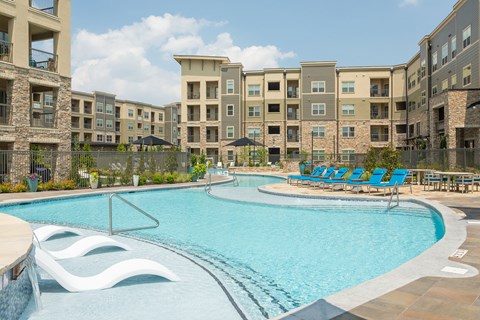A swimming pool in front of apartment buildings.