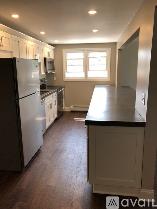 A kitchen with a black counter top and white cabinets.
