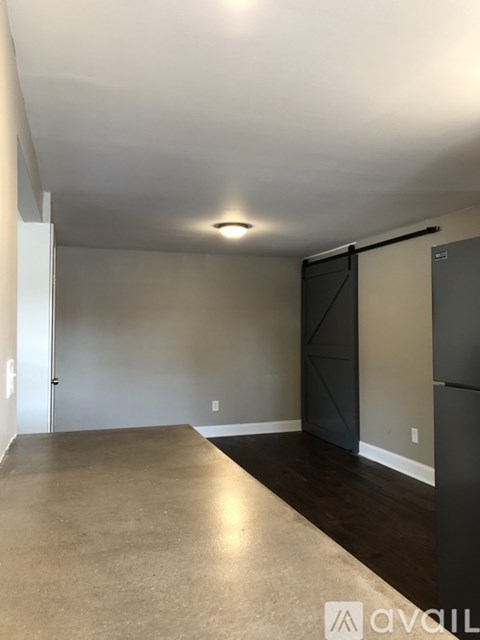 A room with a sliding door and a refrigerator.
