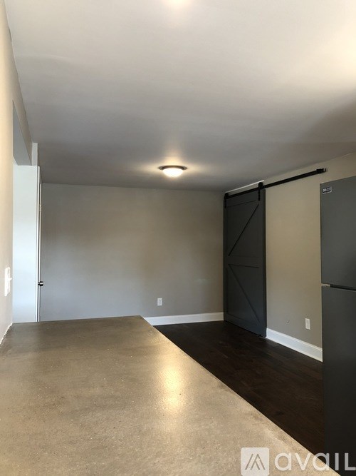 A room with a sliding door and a refrigerator.