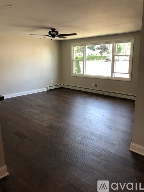 A room with a ceiling fan and a window.