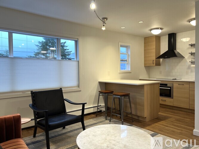 A kitchen with a black chair and a white table.