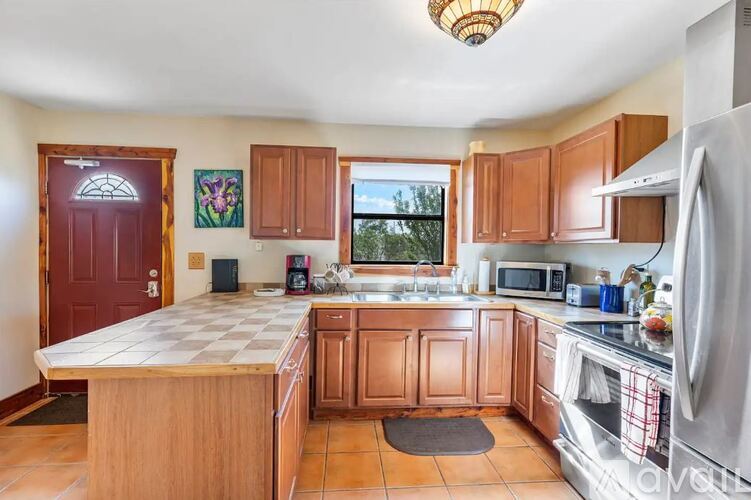 A kitchen with wooden cabinets and a checkered countertop.