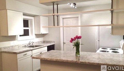 A kitchen with a white door and a marble countertop.