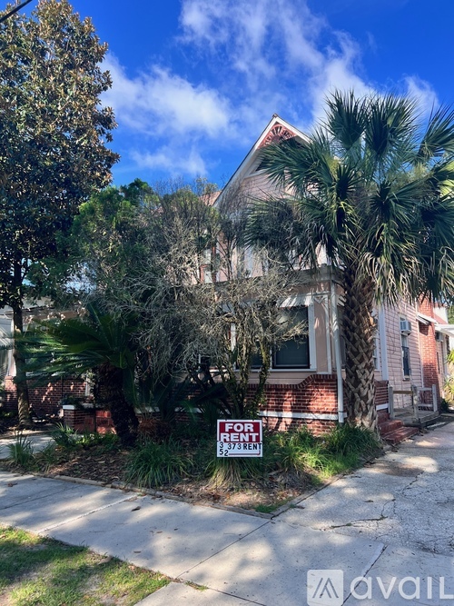 A house with a "For Rent" sign in front of it.
