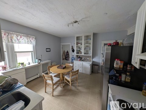 A kitchen with a table and chairs in the middle of the room.
