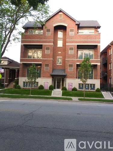 A large red brick house with a tree in front.