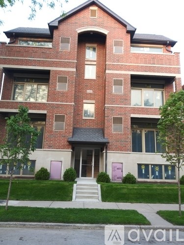 A red brick building with a black roof and a white front door.