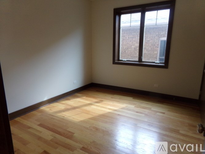 A room with wooden flooring and a window.