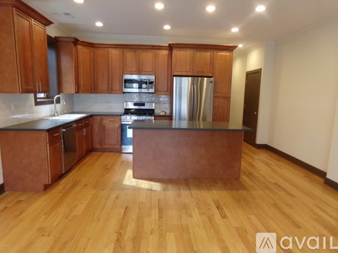 A kitchen with wooden cabinets and a refrigerator.