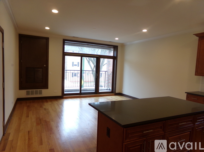 A kitchen with wooden floors and a black countertop.
