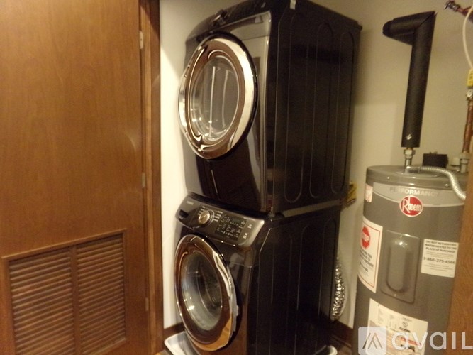 A stack of black washing machines in a laundry room.
