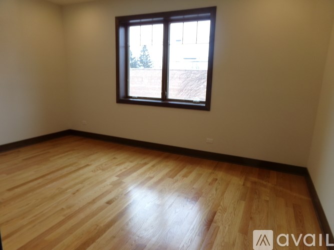 A room with wooden flooring and a window.