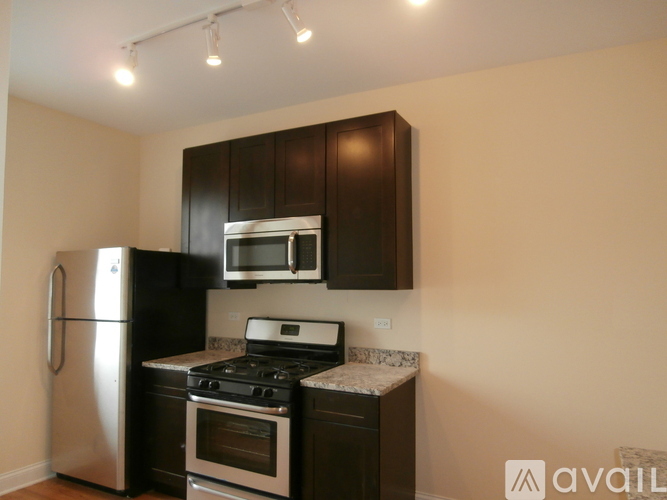 A kitchen with a stainless steel refrigerator, microwave, and oven.