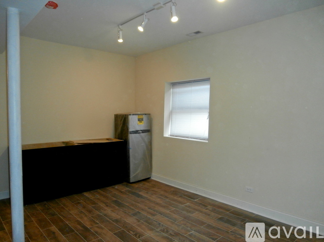 A room with a black counter and a window with blinds.