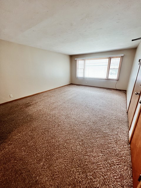 an empty room with carpet and a window